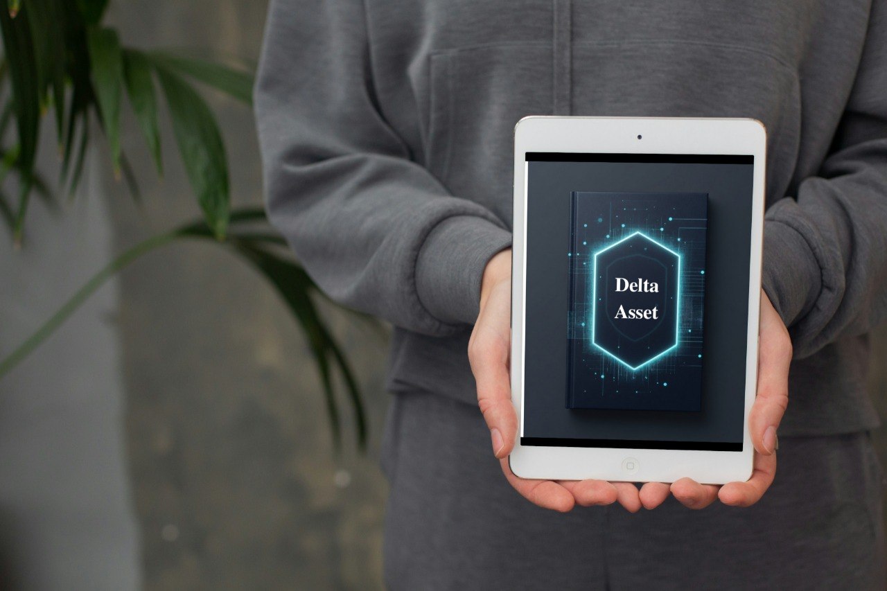 Person holding a tablet with 'Delta Asset' displayed on the screen, blurred background